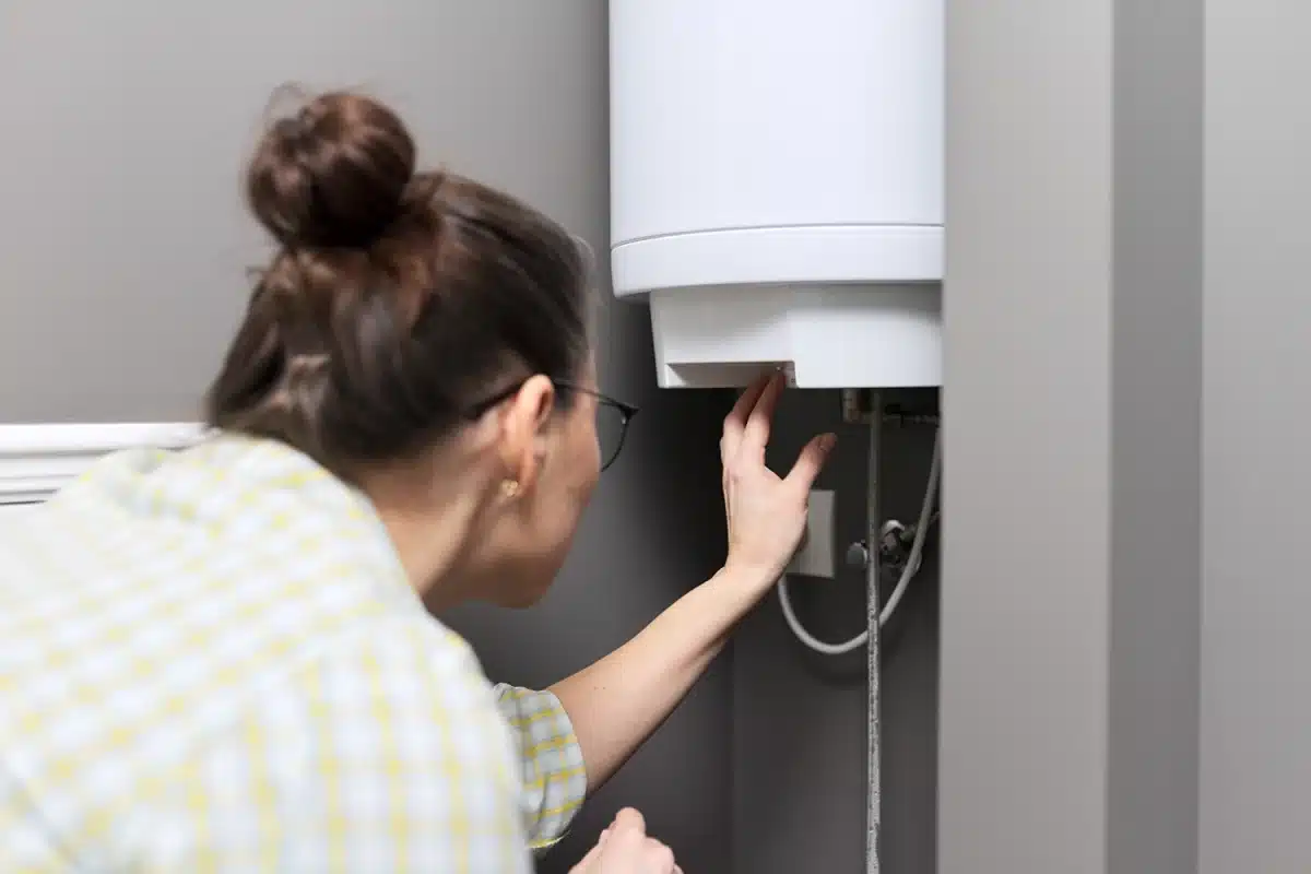 A homeowner checking a newly installed storage water heater in a Singapore home, ensuring the unit is the right fit for their household’s hot water needs